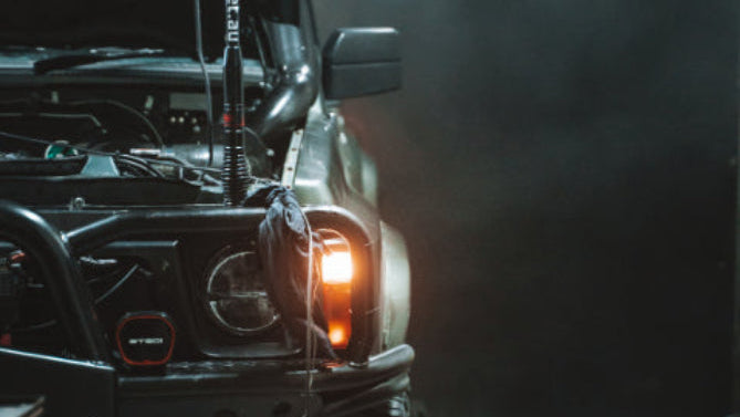 Front view of a vehicle with a light on in a dark setting